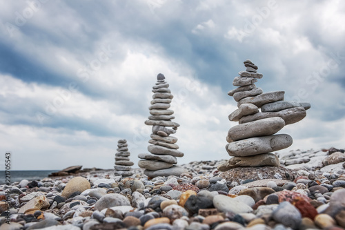 Towers of balanced stones on the beach on a cloudy day
