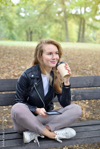 Pretty Young Woman Walking in Autumn Park Relax Leisure Black Leather Jacket Fashion Modern Red Nails Drinking Coffee Take Away Cup