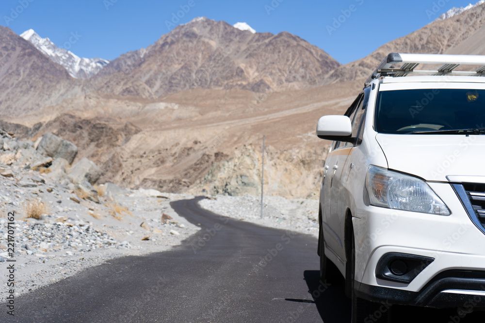 Close up front of car parking on the asphalt road,car for traveling with a roof rack on a mountain road Close up front of car parking on the asphalt road,car for traveling with a roof rack on a mountain road