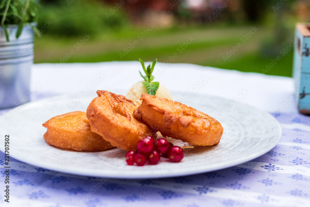 gebackene frittierte Apfelküchle Dessert im Biermantel Teig mit Vanille Eis und Preiselbeeren im Biergarten Oktoberfest serviert gebackene frittierte Apfelküchle Dessert im Biermantel Teig mit Vanille Eis und Preiselbeeren im Biergarten Oktoberfest serviert