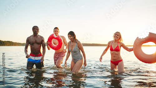 Diverse friends wearing swimsuits enjoying an afternoon at a lak