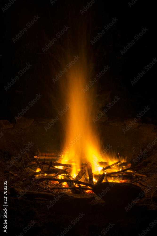 Burning campfire at night. A glowing fire in the darkness. Flying flames from campfire. Burning campfire at night. A glowing fire in the darkness. Flying flames from campfire.