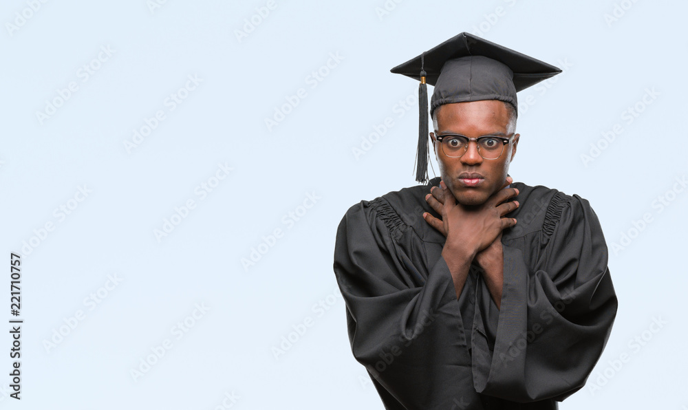 Young graduated african american man over isolated background shouting and suffocate because painful strangle. Health problem. Asphyxiate and suicide concept. Young graduated african american man over isolated background shouting and suffocate because painful strangle. Health problem. Asphyxiate and suicide concept.