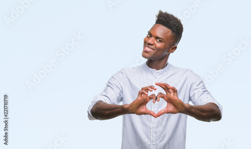 Young african american man over isolated background smiling in love showing heart symbol and shape with hands. Romantic concept.