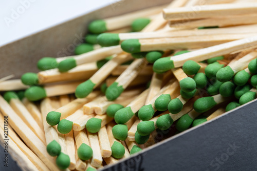 Box full of pile of matches with green heads. Up close macro shot.