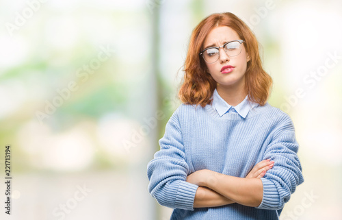 Young beautiful woman over isolated background wearing winter sweater skeptic and nervous, disapproving expression on face with crossed arms. Negative person.