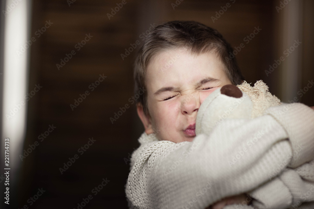A young boy, a serious look is dressed in a knitted white sweater. Portrait A young boy, a serious look is dressed in a knitted white sweater. Portrait