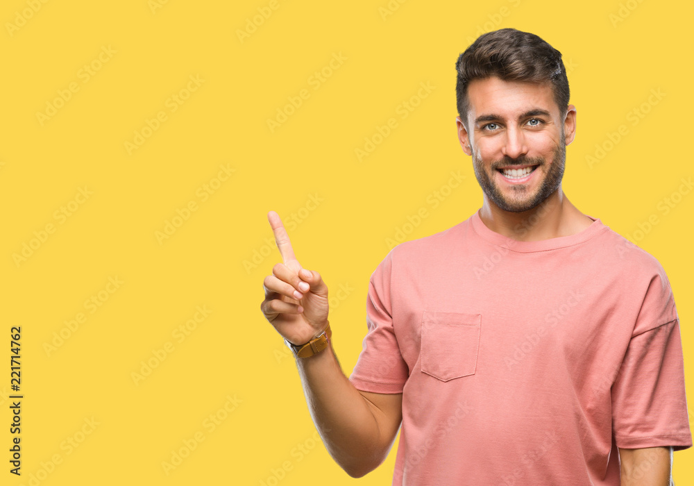 Young handsome man over isolated background with a big smile on face, pointing with hand and finger to the side looking at the camera. Young handsome man over isolated background with a big smile on face, pointing with hand and finger to the side looking at the camera.