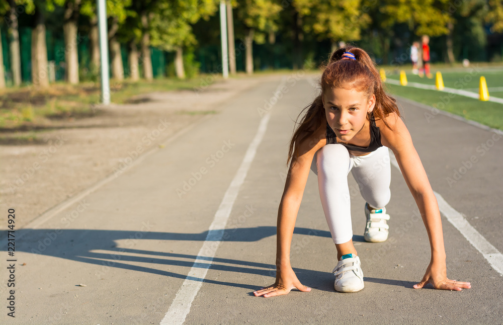 Teenage girl at the start for running in the stadium