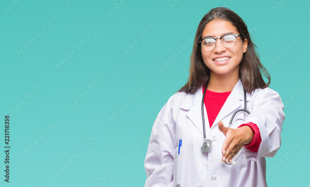 Young arab doctor woman over isolated background smiling friendly offering handshake as greeting and welcoming. Successful business. Young arab doctor woman over isolated background smiling friendly offering handshake as greeting and welcoming. Successful business.