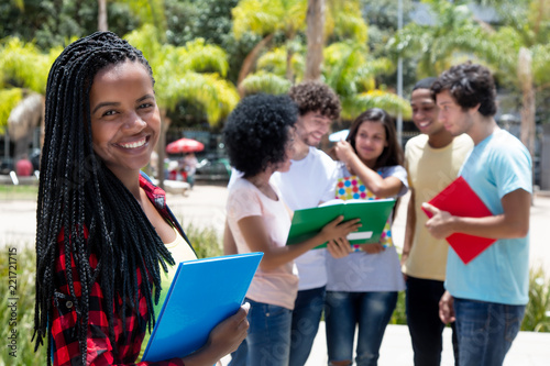 Laughing african female student with group of students