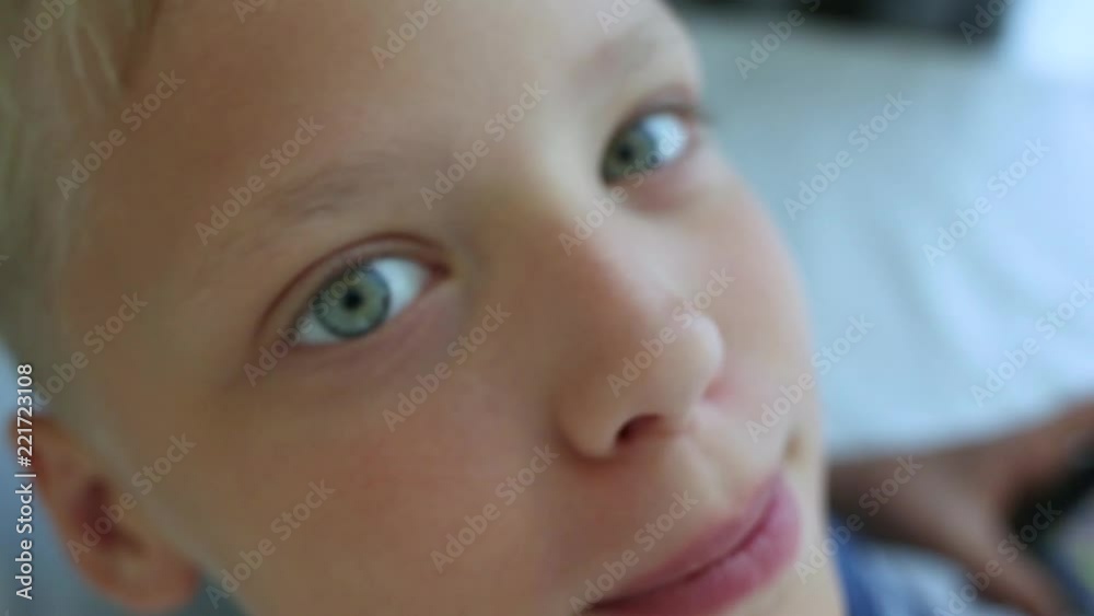 Top view closeup video portrait of cute happy smiling young kid playing computer games using modern black smartphone. Macro shoot of lovely boy's grey eyes. Real time full hd footage. Top view closeup video portrait of cute happy smiling young kid playing computer games using modern black smartphone. Macro shoot of lovely boy's grey eyes. Real time full hd footage.