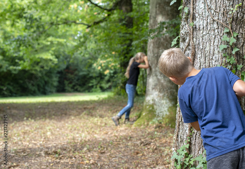 Kids playing hide and seek in the forrest  photo
