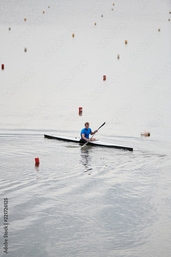 Naklejka premium Young kayaker studying to float on kayak on the lake