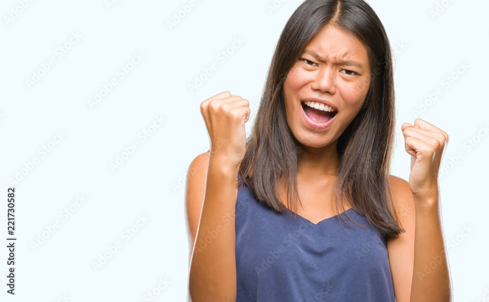 Young asian woman over isolated background very happy and excited doing winner gesture with arms raised, smiling and screaming for success. Celebration concept. Young asian woman over isolated background very happy and excited doing winner gesture with arms raised, smiling and screaming for success. Celebration concept.
