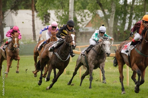 Jockeys and their horses are running to the finish line