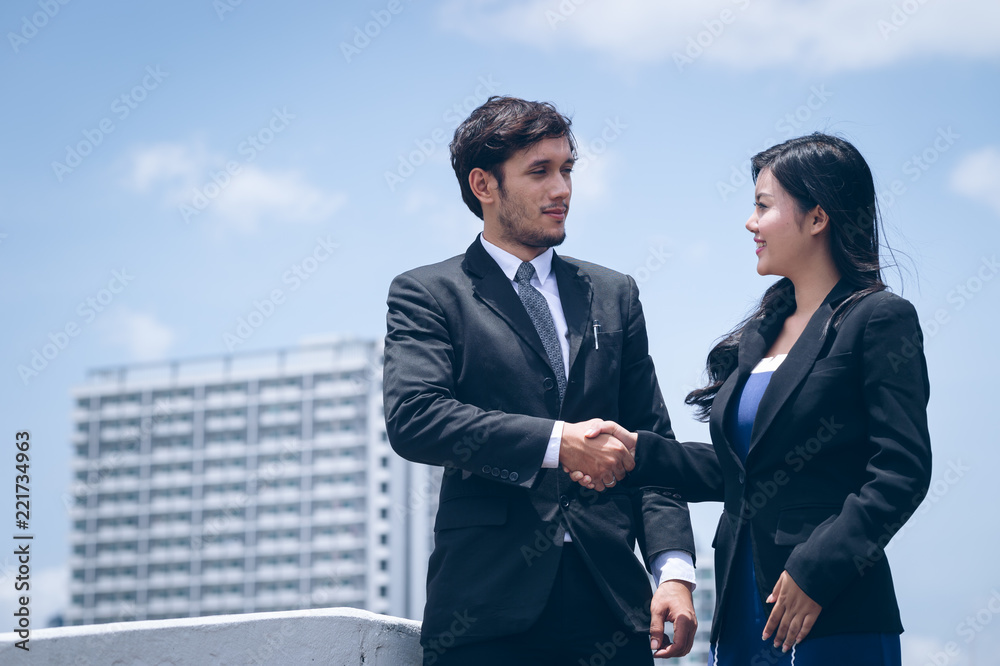happy handshaking confident businessman and associates standing at outdoor happy handshaking confident businessman and associates standing at outdoor