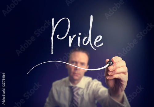 A businessman writing a pride concept with a white pen on a clear screen.
