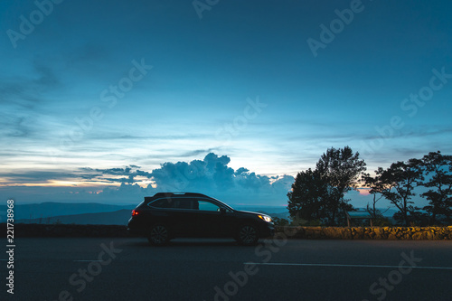 A black Subaru Outback is parked in front of an overlook in Shenandoah National Park, VA at sunset.