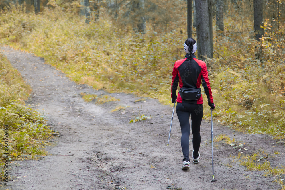 woman practicing nordic walking in nature woman practicing nordic walking in nature