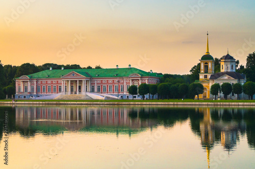 Fofmer aristocratic mansion and church with bell tower next to the palace pond in the State reserve museum Kuskovo, former summer country estate of the 18th century. Moscow. Russia.