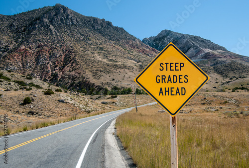 Photography Steep Grades Warning Sign:  A sign warns of a steep climb ahead on a road leadin