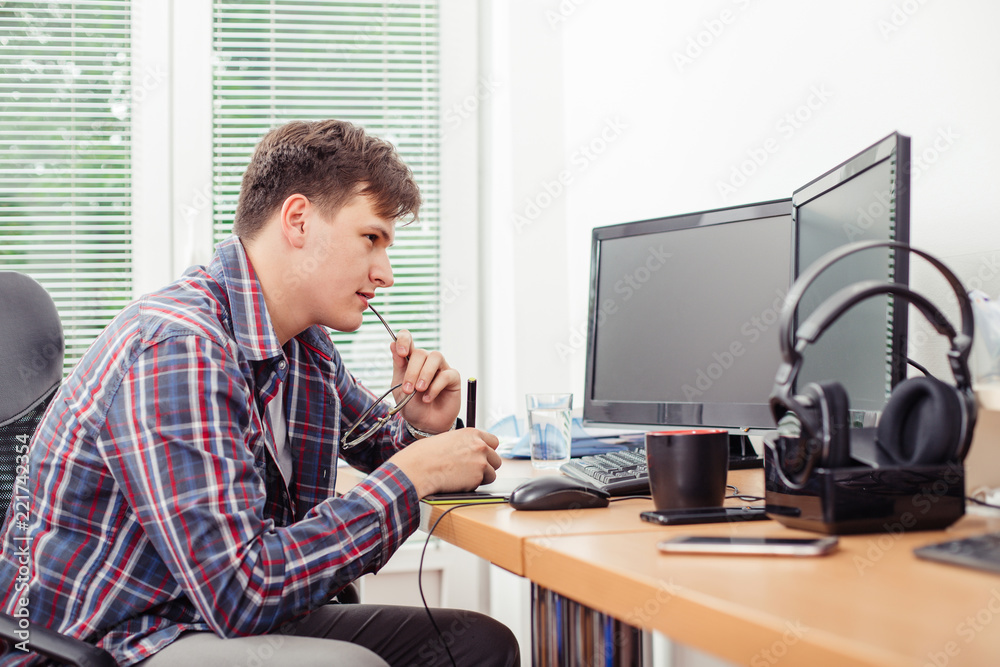 Man using graphics tablet to work in office Man using graphics tablet to work in office
