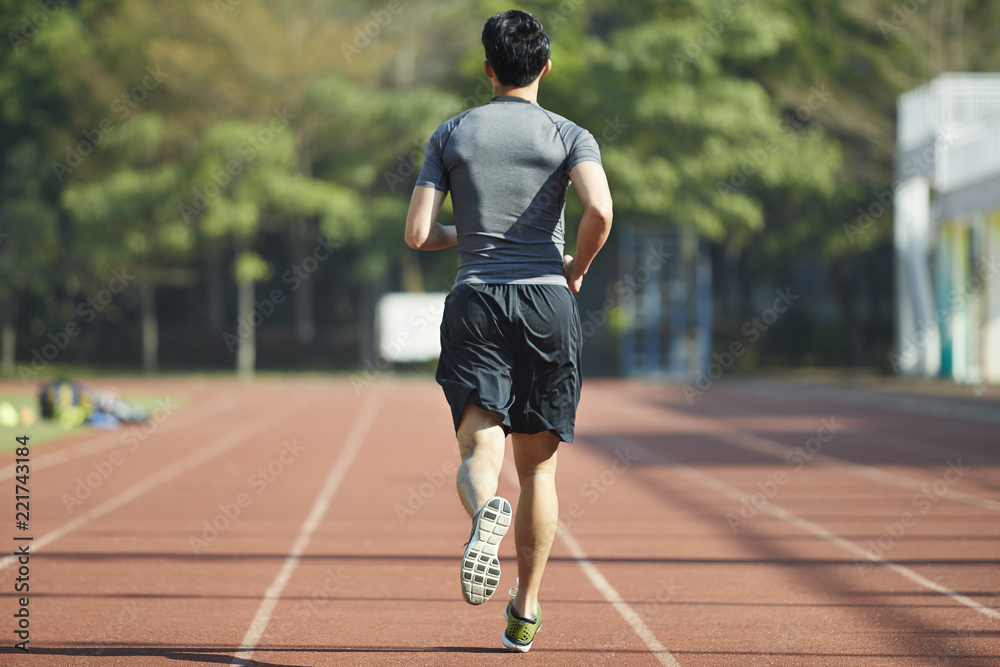 young asian male athlete running on track young asian male athlete running on track