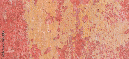 Old weathered painted wall background texture. Red dirty peeled plaster wall with falling off flakes of paint. © vejaa