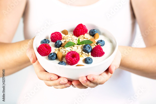 Gesundes Müsli mit Haferflocken, Joghurt, Himbeeren, Blaubeeren und Mandeln