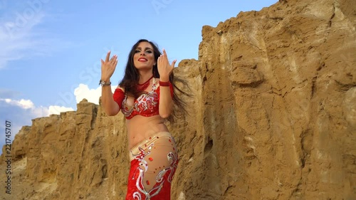 Oriental Beauty dancing sensual belly dance outdoors. Arab dance of seduction. Girl rhythmically moves his arms and thighs.