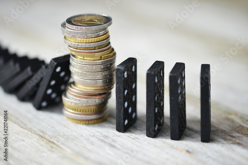Strong currency or economy concept with pile of coins stopping the fall of black domino blocks
 photo