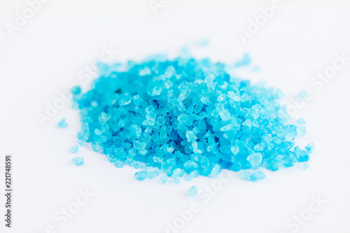 Close up shot of blue crystals isolated on white background, chemical industry concept