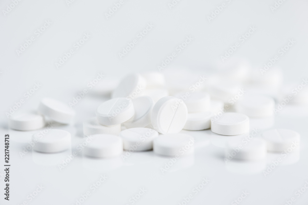 Close up shot of breakable white pills on white background, copy space Close up shot of breakable white pills on white background, copy space