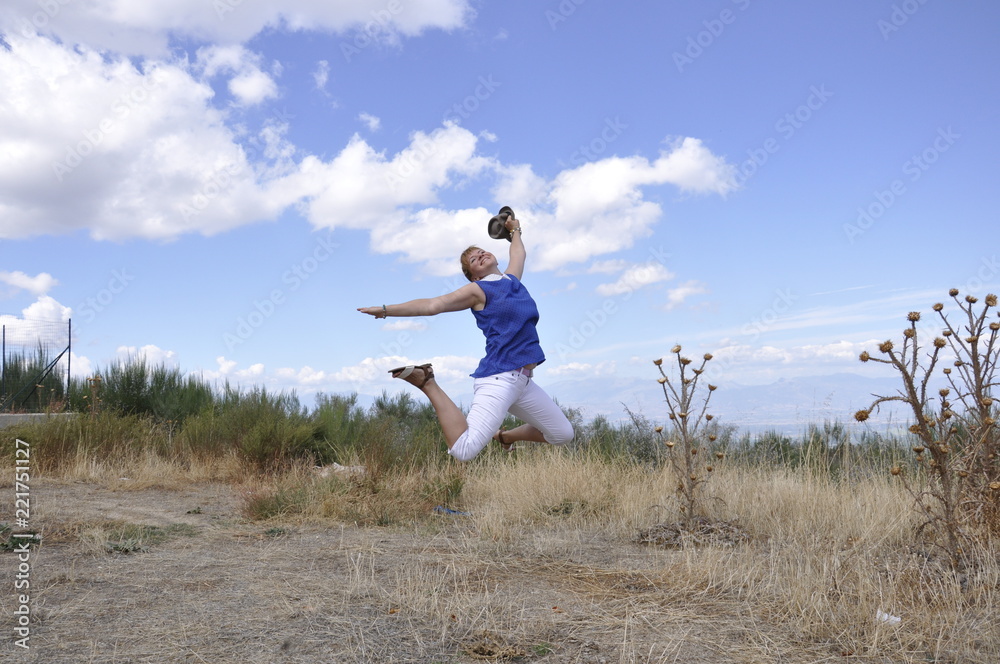 A young European girl, white against the blue sky of Italy jumped up with a smile. A young European girl, white against the blue sky of Italy jumped up with a smile.