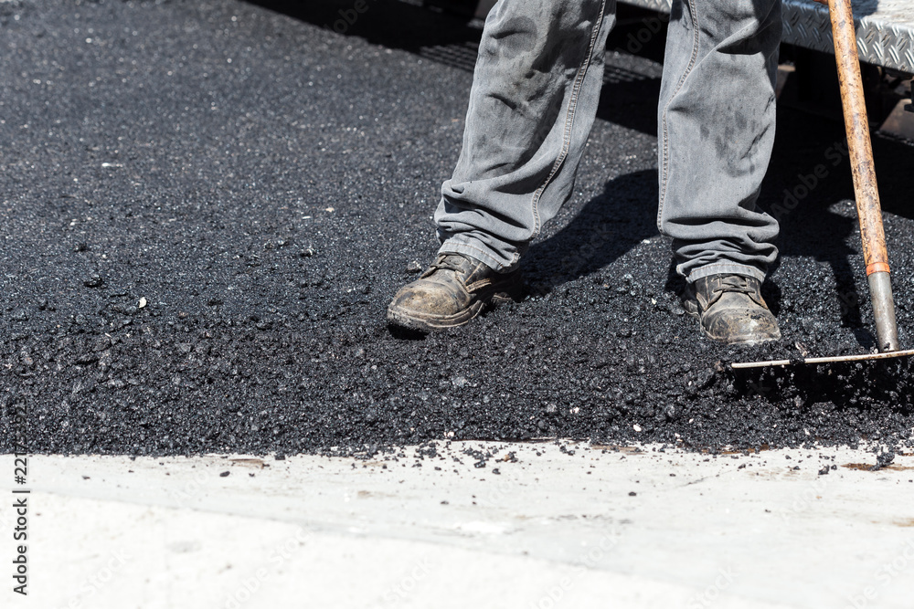 Worker navigating pavement truck Worker navigating pavement truck