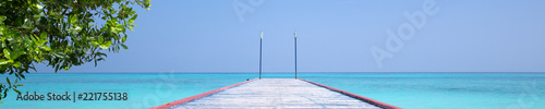 Tropical travel destinations with Maldives island and wooden wharf © photopixel