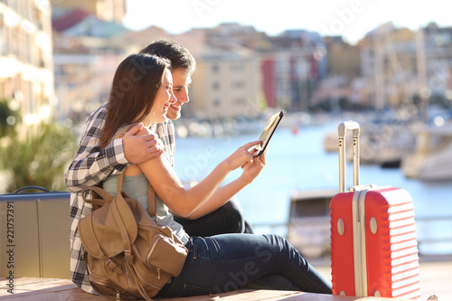 Vászonkép Couple of tourists consulting a tablet on vacation