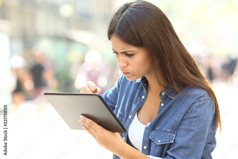 Angry girl having online problems with a tablet Angry girl having online problems with a tablet