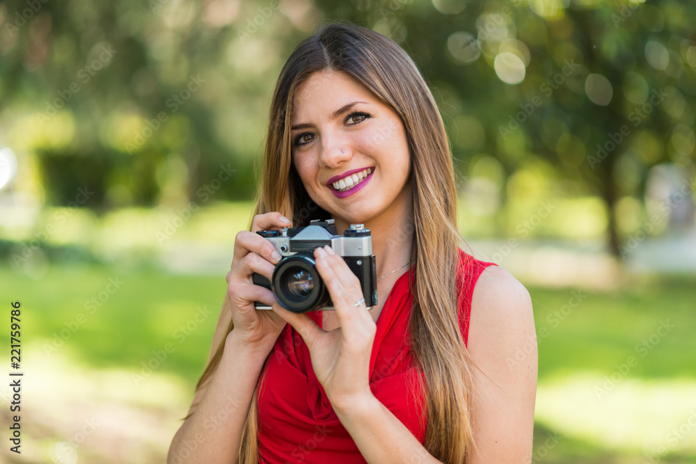 Smiling young woman holding a camera