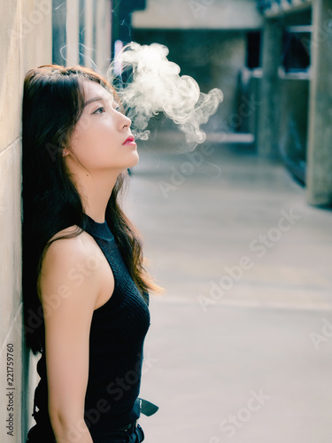 Portrait of beautiful Chinese girl smoking outdoor and thinking about  problems, seems a little bit lost, in vintage mode. Stock Photo | Adobe  Stock