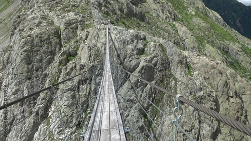 Walk through Trift Bridge, around lake, glacier and mountains, national park Switzerland, Europe. Summer landscape, sunshine weather and sunny day photo