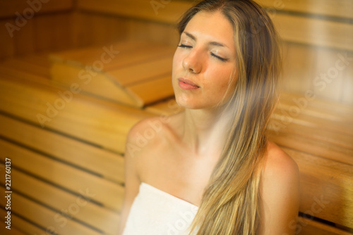 Beautiful woman having a sauna bath in a steam room