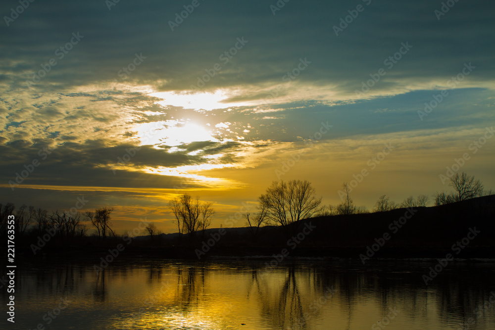 Obraz premium Bright Orange Sunset Over Calm River 