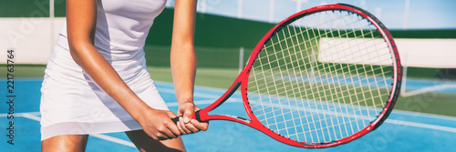 Tennis player woman in position holding red racket on outdoor blue tennis court banner panorama header for tennis classes at sports club.