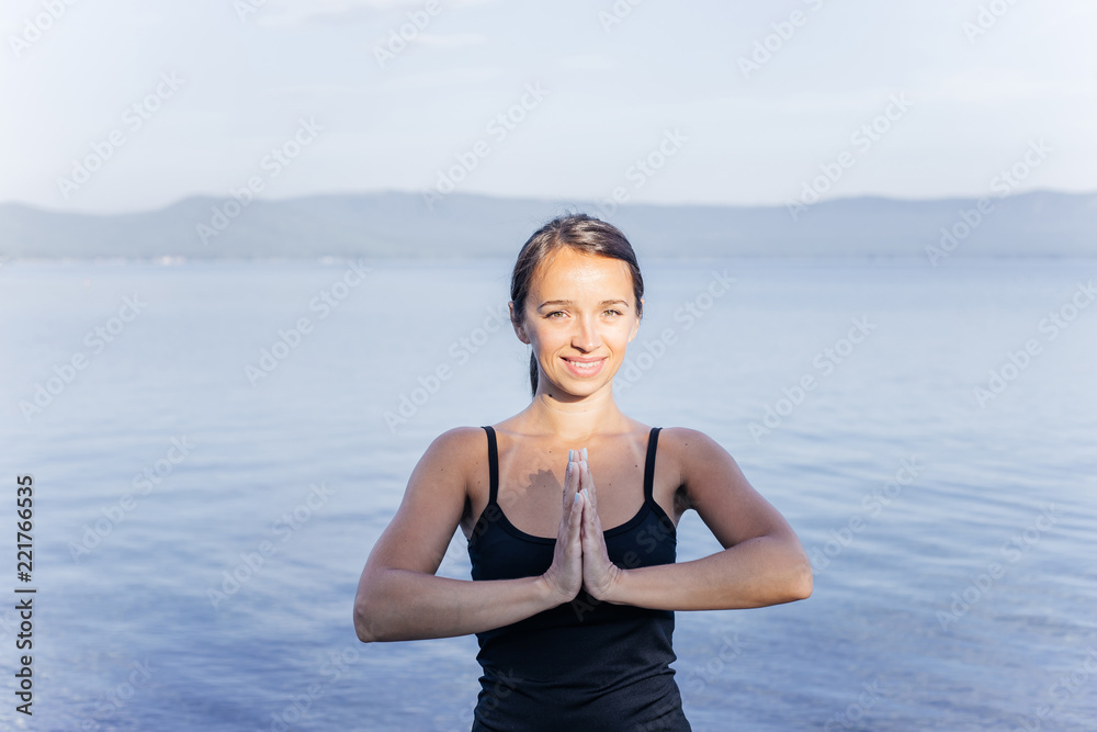 Young attractive smiling woman practicing yoga on a lake Young attractive smiling woman practicing yoga on a lake