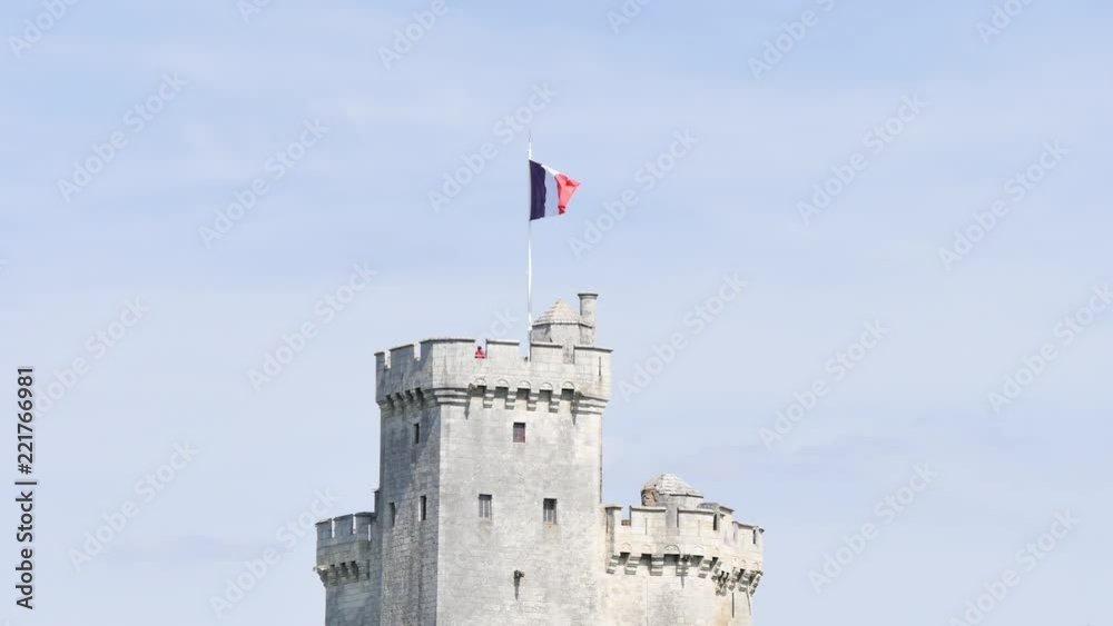 Drapeau français au dessus d'une tour du vieux port de La Rochelle, une ville française dans l'ouest de la France. Filmé pendant l'été. La tour s'appelle en Français 