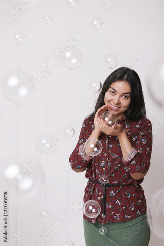 beautiful girl among the glass balls one of which she holds in her hands