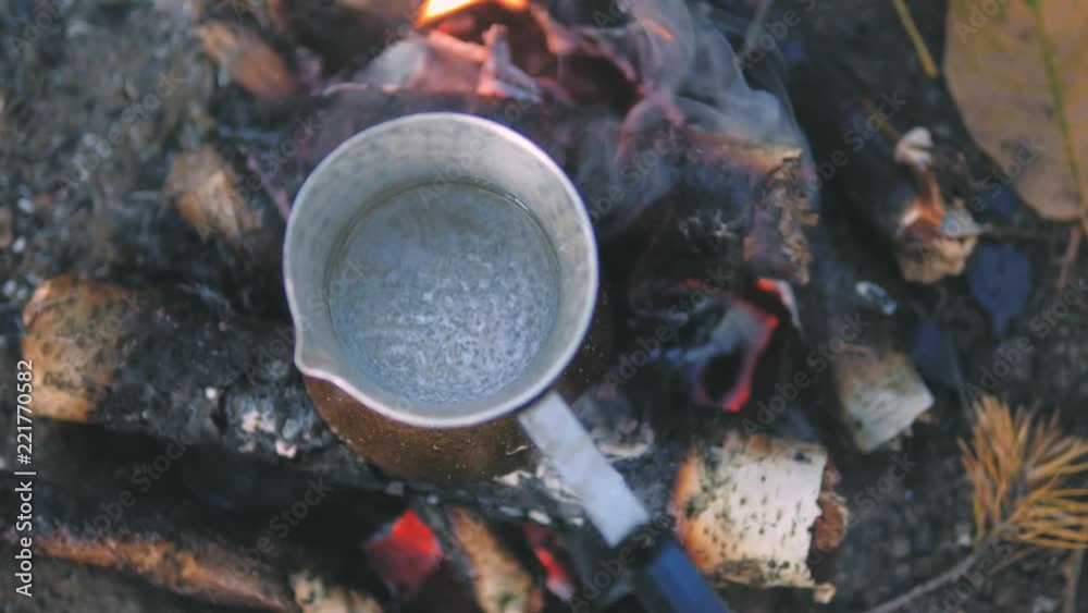 Making coffee in cezve on fire. Bonfire in a beautiful autumn forest. Camp Fire. Making coffee in cezve on fire. Bonfire in a beautiful autumn forest. Camp Fire.