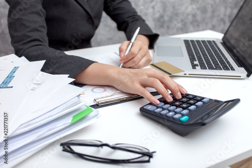 Business women using calculator at working with financial reports